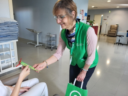 Una voluntària de l'Associació contra el Càncer lliurant un obsequi a una pacient de l'Hospital de Dia Oncològic.