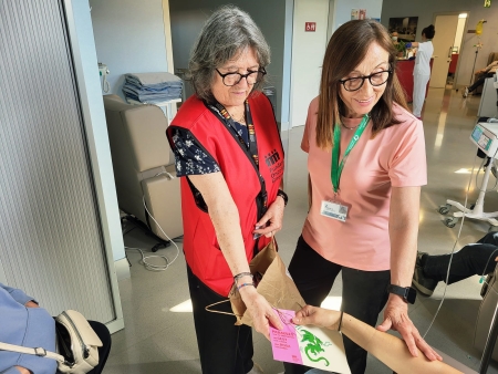 Voluntàries d'Oncolliga lliurant un obsequi a una pacient de l'Hospital de Dia Oncològic.