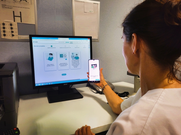 L'optometrista Isabel Berrojo amb l'evisio al mòbil i al pc